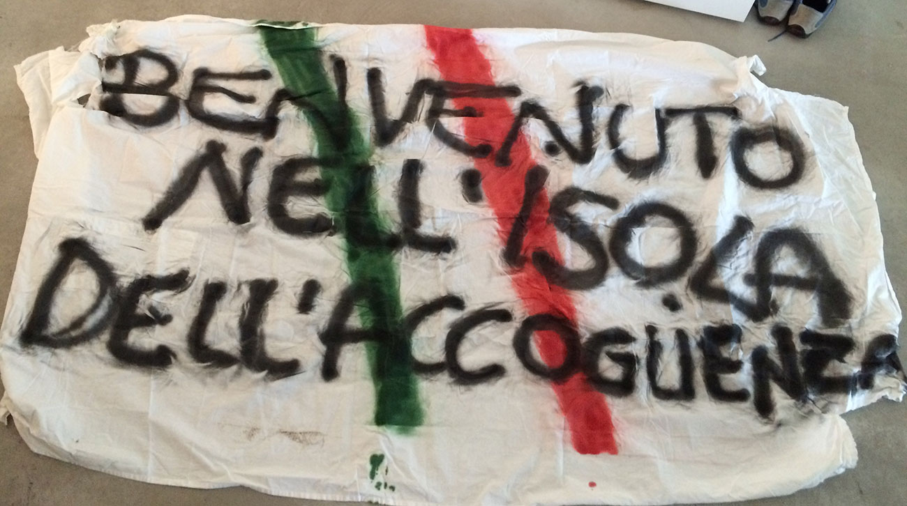 Banderole de manifestation « Benvenuto nell isola dell'accoguenza » Italie, Pélages, Lampedusa 2016 © DR