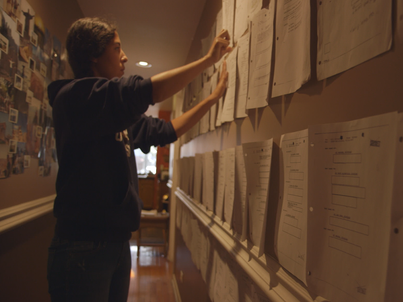 The Feeling of Being Watched Director Assia Boundaoui assembling FBI documents from Operation Vulgar Betrayal. From The Feeling of Being Watched, directed by Assia Bouadaoui. Courtesy of Watched Film, LLC